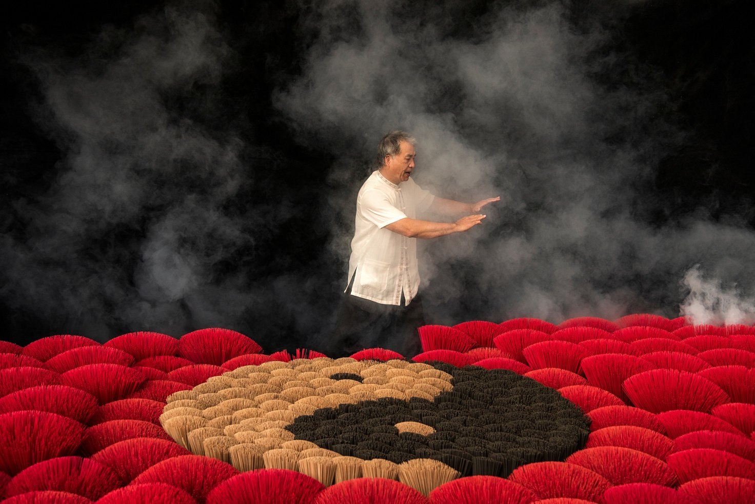 Man Practicing Tai Chi Next to Incenses Forming Ying Yang Symbol