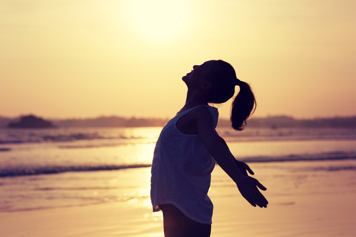 Woman enjoy the harmony on sunset beach